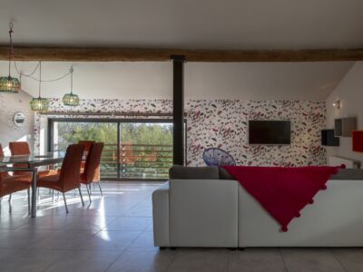 Le canapé face a la baie vitrée permet de profiter de la vue sur la piscine . En changeant le sens de la table l'espace salle a manger est mieux défini et la circulation plus fluide.